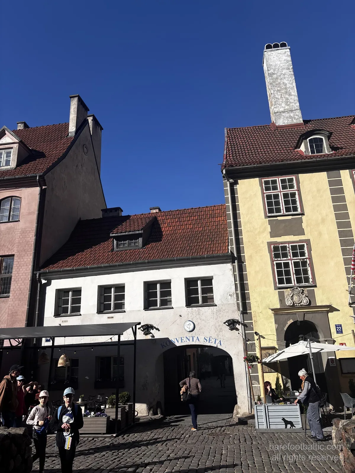 The Konventa Sēta arched entrance from Kalēju iela in Riga Old Town, Latvia, with the ‘KONVENTA SĒTA’ sign over the arch.