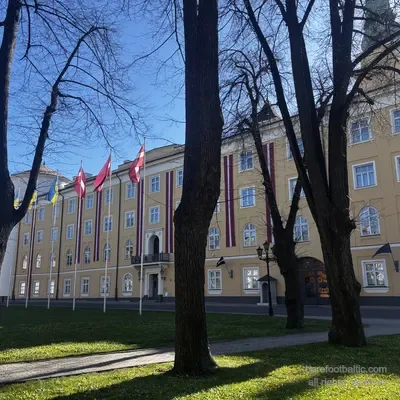 Pils laukums in primavera con le bandiere del castello tra gli alberi spogli, Riga, Lettonia