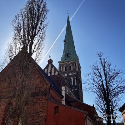 Sv. Jēkaba katedrāles smaile no apakšas ar lidmašīnas pēdu debesīs, Rīga, Latvija