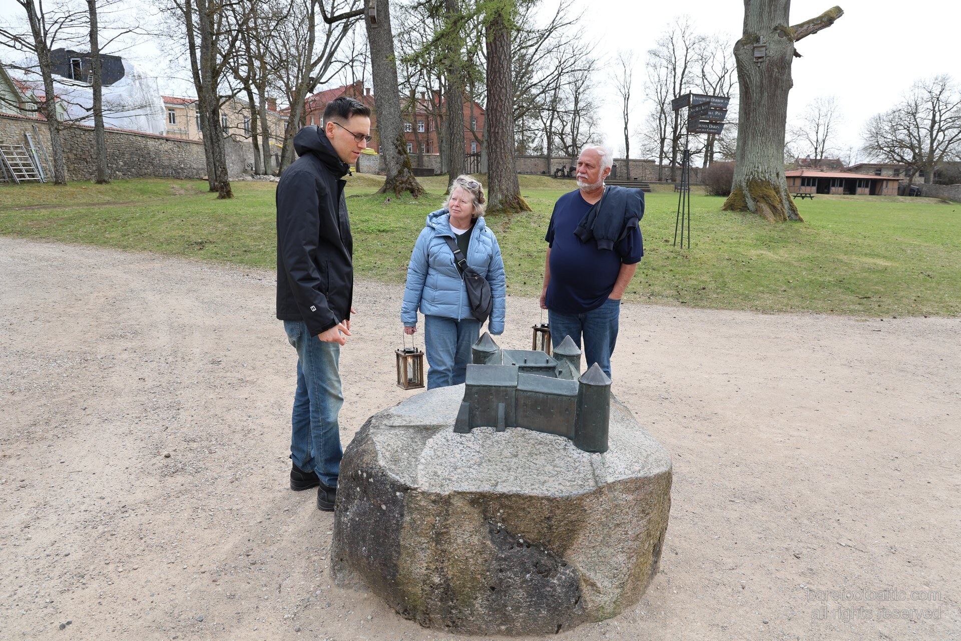 Visitors inspecting the bronze scale model of the Cēsis castle complex, Latvia
