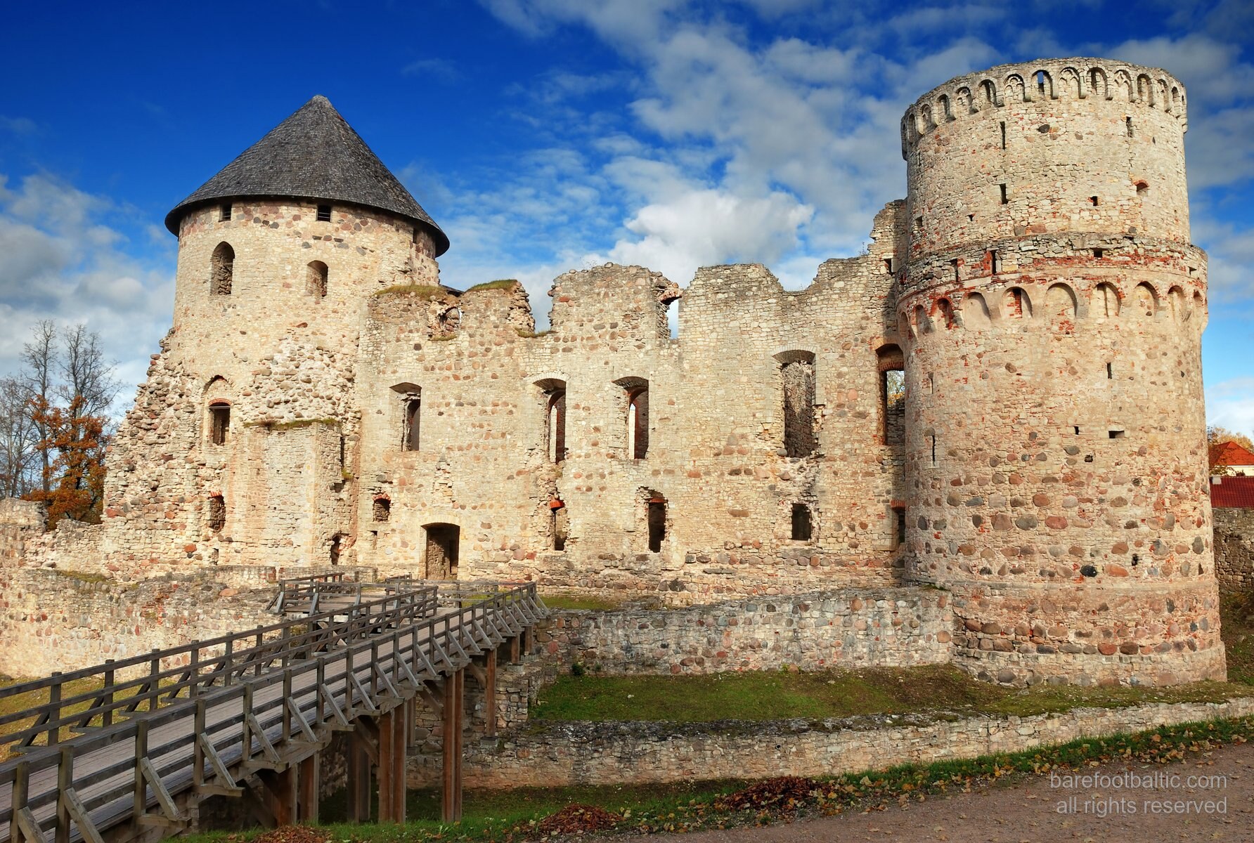 Exterior of the medieval Cēsis Castle ruins, red brick walls in autumn light, Latvia
