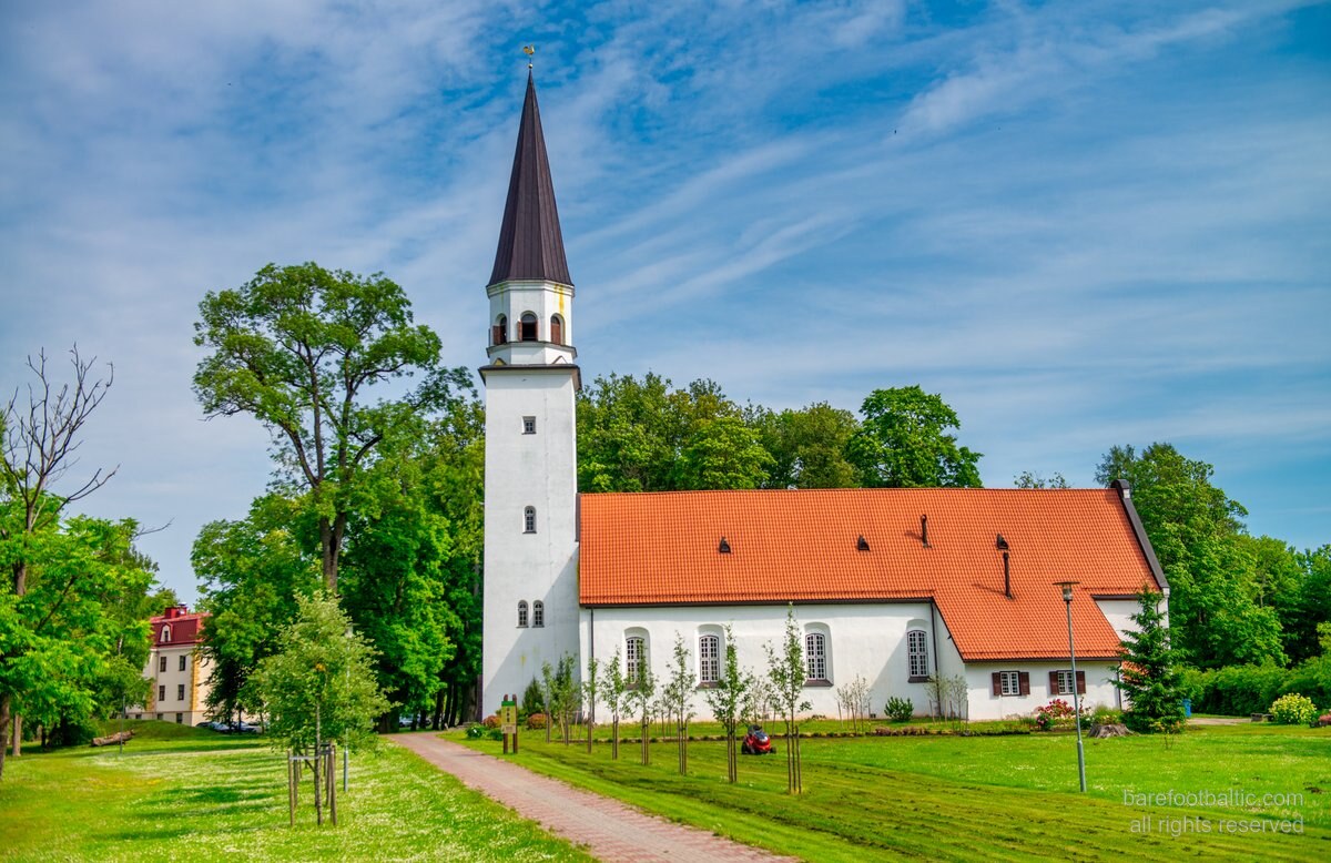 The spire of St. John's Church (Sv. Jāņa baznīca) above the rooftops of Cēsis Old Town, Latvia